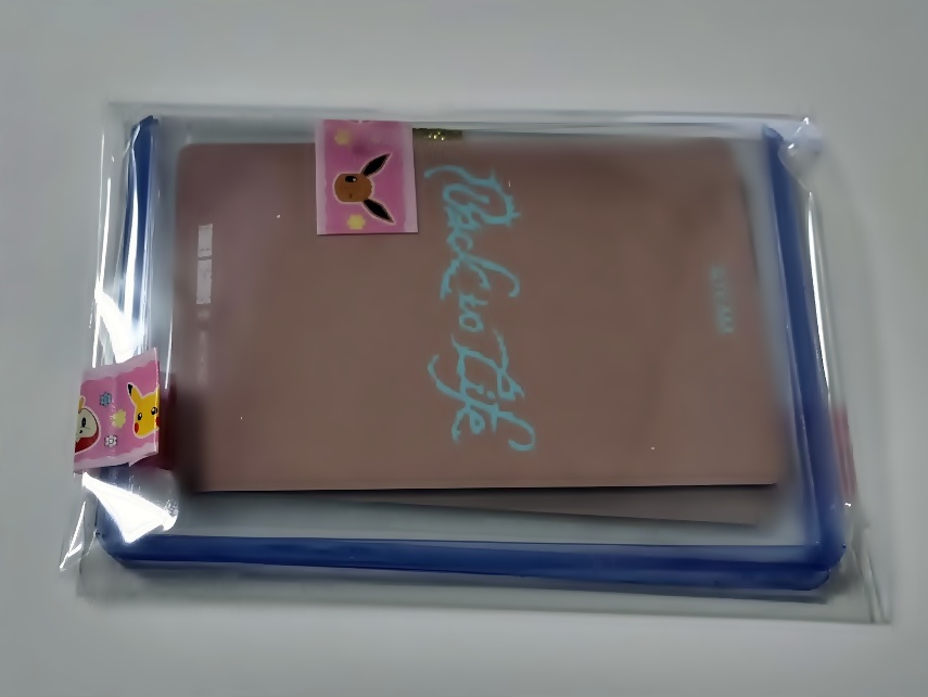 硬質ケースに入れたトレカを防水用のOPP袋に入れ、マスキングテープで封をした最終梱包の状態(裏面)